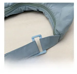 Detail of light blue nylon bag featuring plastic strap buckles and fine double stitching