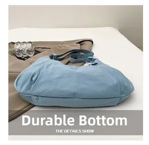 Detail shot of a blue nylon tote bag highlighting the durable bottom and wrinkled texture