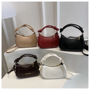 Collection of half-moon crossbody bags in five colors with knot handles and gold lettering