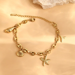 Gold stainless steel ocean bracelet with starfish and seashell charms on peach background