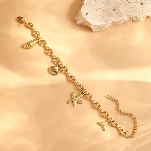 Close-up of golden stainless steel ocean charms with seashell and starfish details