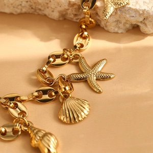 Golden stainless steel bracelet with starfish and seashell charms on coffee bean chain