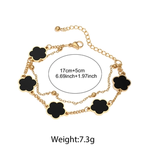 Detail der doppelten Goldkette mit schwarzen fünfblättrigen Blumen und Perlenrand