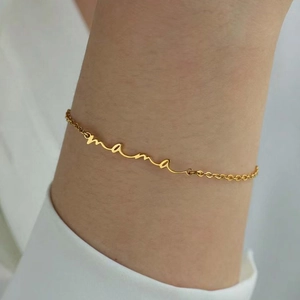 Vue détaillée d'un bracelet gourmette en acier doré avec le mot mama porté au poignet