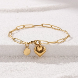 Détail du bracelet chaîne trombone en acier doré avec pendentifs cœur et rond