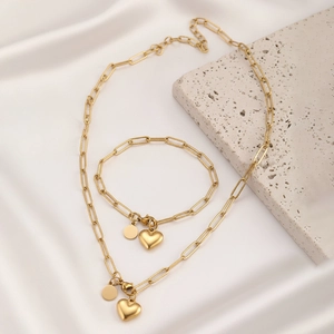 Parure de bijoux dorés avec chaîne trombone et pendentifs cœur sur soie et pierre