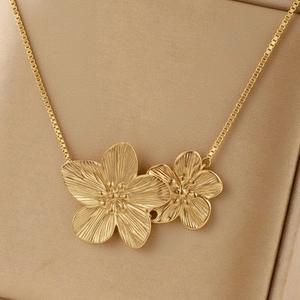 Close-up of golden double flower pendant with brushed texture on box chain necklace