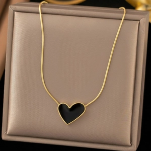 Golden snake chain necklace featuring a black heart pendant in a velvet jewelry box