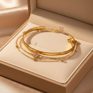Ensemble bracelet doré avec zircon et chaîne sur un luxueux satin couleur champagne