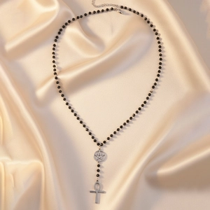 Collier gothique en perles avec croix Ankh argentée et pendentif étoile sur du satin
