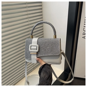 Detail of silver glitter flap and grey matte leather crossbody bag with square buckle