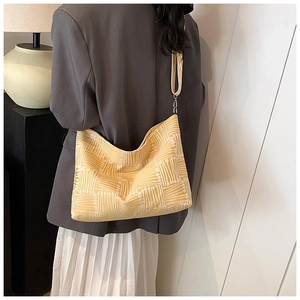 Detail of yellow geometric pattern tote bag with wide strap worn on casual outfit