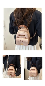 Detail of pink cat-shaped mini backpack with metal chain straps and embroidery