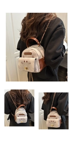 Detail view of mini cat-shaped backpack with embroidery and metal chain straps