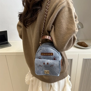 Mini blue denim backpack with cat design and brown leather straps for daily styling