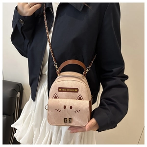 Detail showing beige mini backpack with cute animal embroidery and gold chain strap