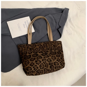 Detail of leopard print tote bag with soft texture and leather handles on casual clothes
