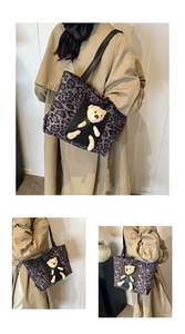 Detail of leopard print tote bag with plush bear charm and black shoulder strap