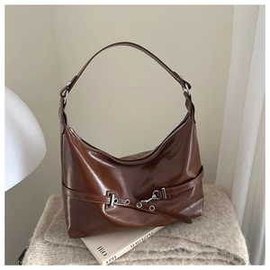 Brown vintage hobo shoulder bag with silver buckles on a soft textured background
