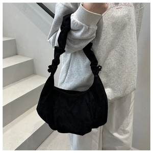 Détail du sac à bandoulière noir avec texture plissée et anse style scrunchie