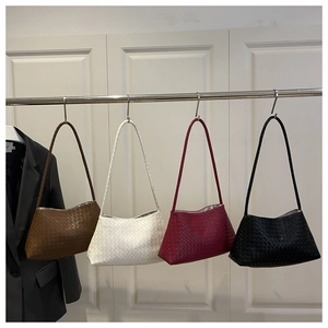 Vista dettagliata delle borse tote intrecciate appese in marrone, bianco, rosso e nero