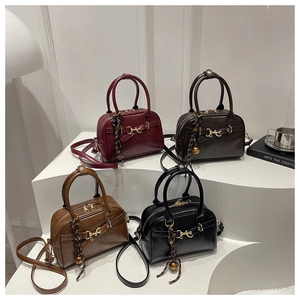 Detail of four retro Boston bags in burgundy, brown, and black with metallic horsebit