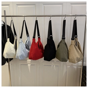 Row of colorful nylon crescent crossbody bags hanging on a rack showing various colors