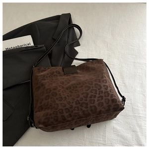 Detail view of leopard print tote bag with brown velvet texture and black shoulder straps