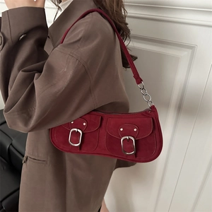 Chic red suede underarm baguette bag with decorative buckles and metal chain strap