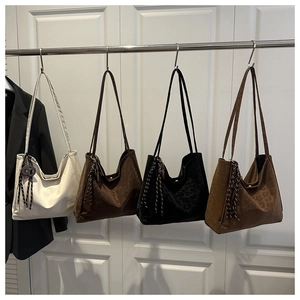 Detail of suede tote bags in white, coffee and leopard patterns with braided tassels