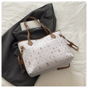 Detail of cute tote bag with bear patterns resting on a chic grey blazer outfit