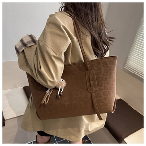 Détail du sac cabas à imprimé léopard en daim marron foncé avec charm peluche