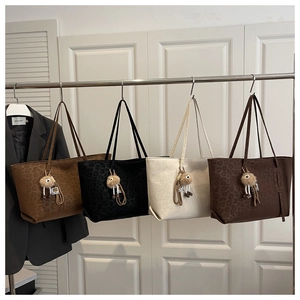 Detail view of leopard print tote bags in four colors with plush ball charms