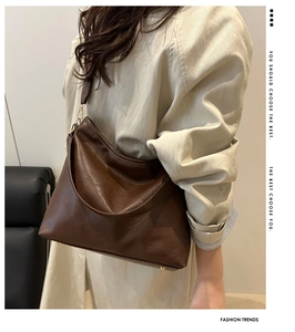Detailed view of brown PU leather texture and gold hardware on a large hobo bag