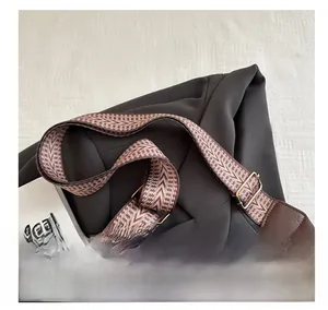 Close-up of geometric ethnic style wide shoulder strap with golden metal buckle and leather