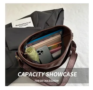 Detail view of large capacity brown tote bag interior with patterned shoulder strap