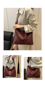 Close-up of a burgundy large hobo bag with textured leather and a patterned wide strap