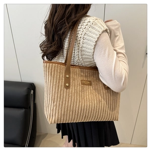 Detail showing beige corduroy texture and brown leather strap with metal rivets