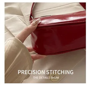 Close-up of precise stitching and oil wax leather texture on red underarm bag