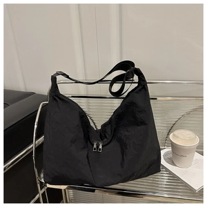 Détail du sac croissant en nylon noir avec doubles zips argentés et large bandoulière