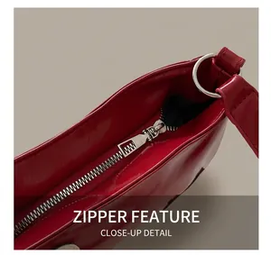 Detailed macro view of silver metal zipper and red patent leather texture on the bag