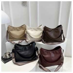 Detail view of five stylish hobo bags in assorted colors with wide jacquard straps