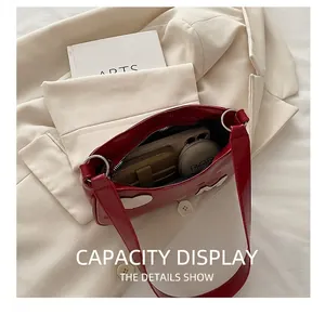 Interior view of the red patent leather shoulder bag showing storage for phone and wallet