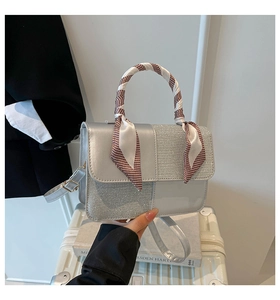 Detailed view of silver crossbody bag with sequin patchwork and silk scarf wrapped handle
