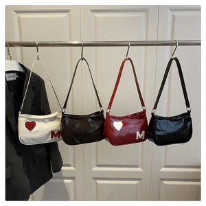 Detail of four colorful baguette bags with heart patches and letter M embossing