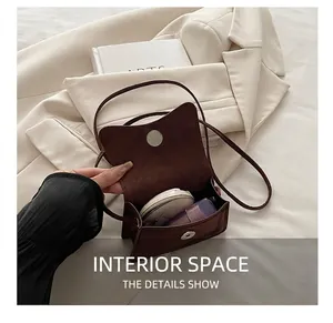 Interior view of small dark brown suede crossbody bag showing capacity for makeup items