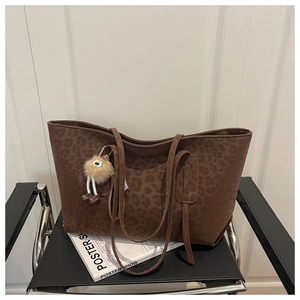 Détail du sac cabas imprimé léopard marron foncé avec un porte-clés en peluche