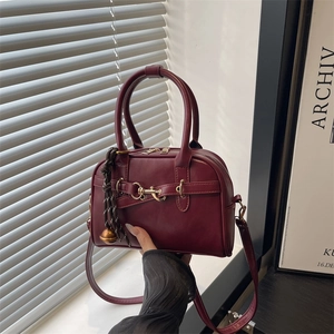 Burgundy Boston shell bag with golden horsebit hardware and woven tassel detail