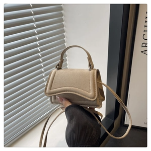 Detail of beige faux suede mini handbag featuring top handle and fine stitching details