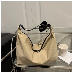 Détail du sac à bandoulière beige minimaliste avec fermeture éclair noire